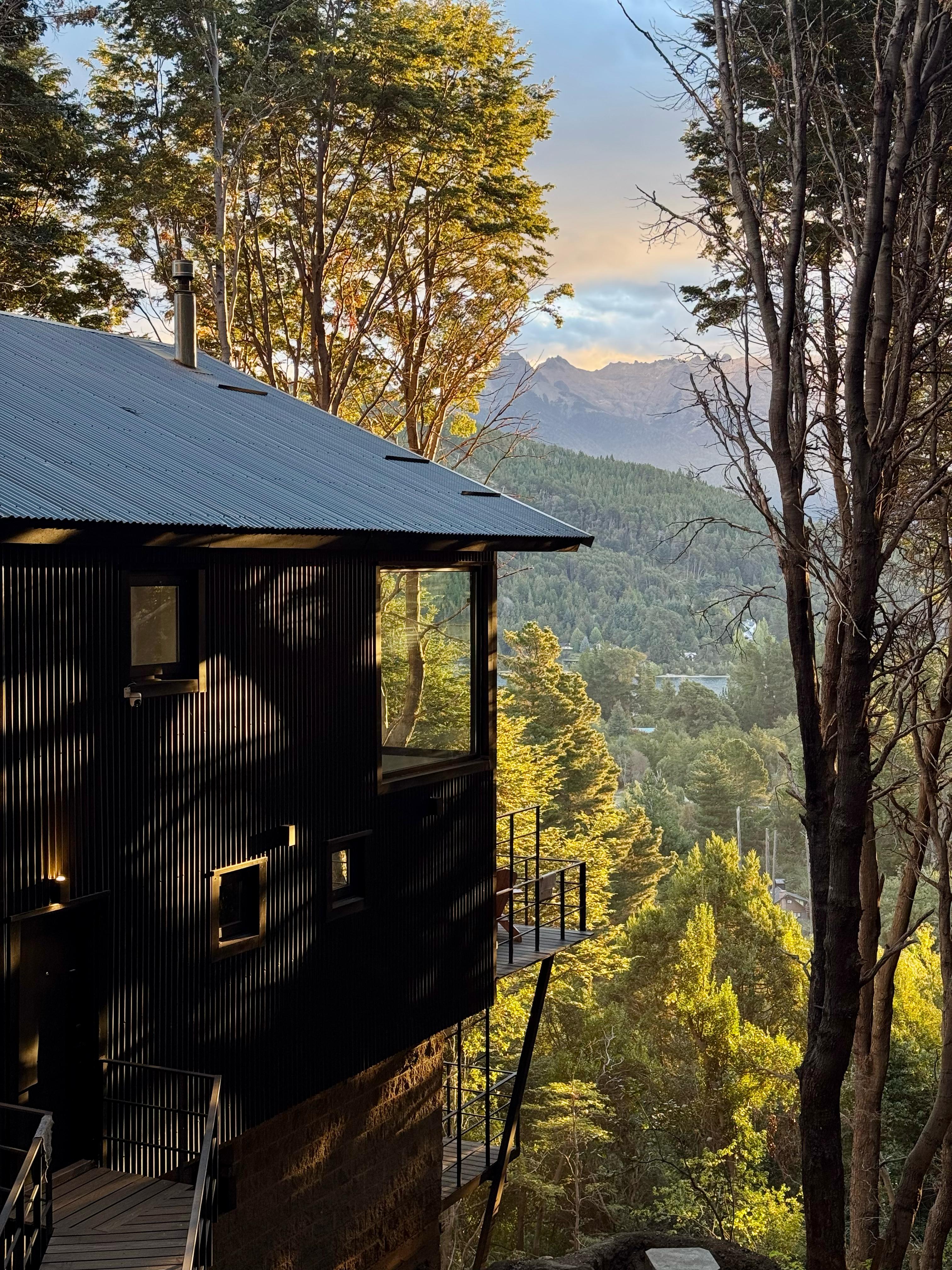 Posta Bariloche — black tower rising through coihue forest at golden hour