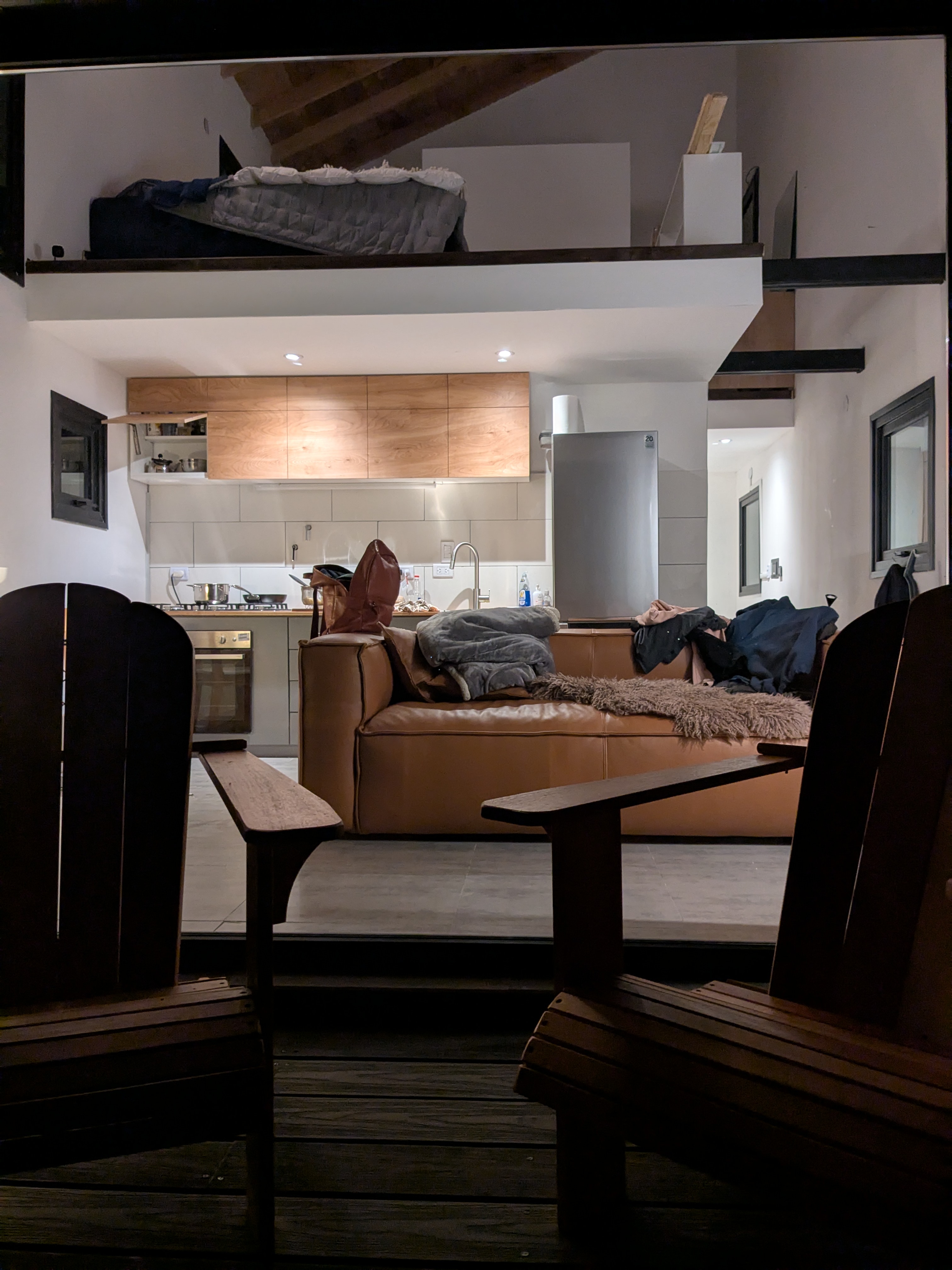 Interior at night — kitchen, loft bedroom visible above
